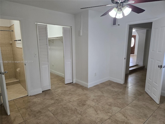 unfurnished bedroom with light tile patterned floors, a closet, and ceiling fan