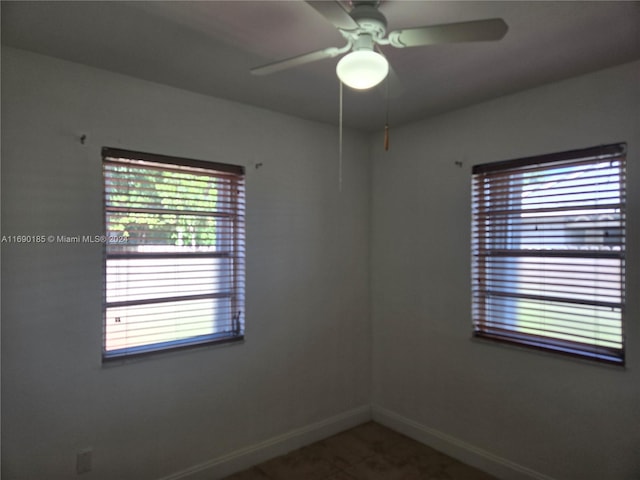 spare room featuring ceiling fan and a healthy amount of sunlight