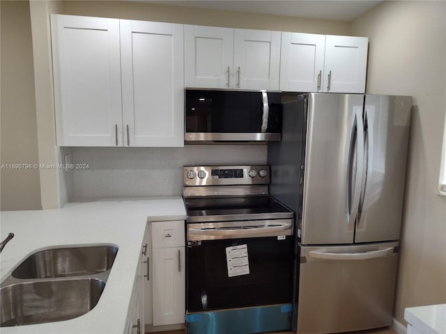 kitchen featuring sink, white cabinets, and appliances with stainless steel finishes