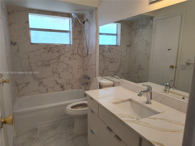 full bathroom featuring vanity, tiled shower / bath combo, and toilet