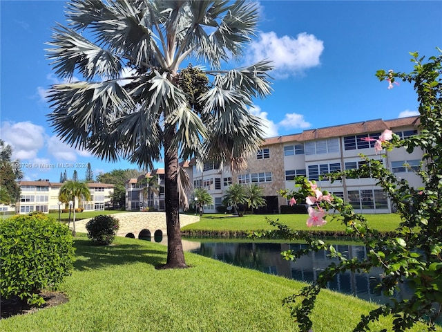 surrounding community featuring a lawn and a water view