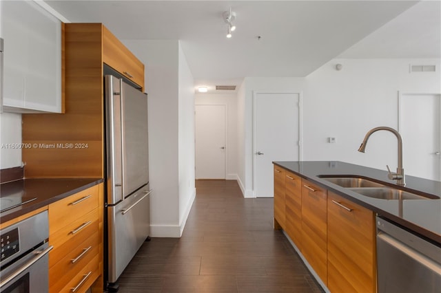 kitchen with dark wood-type flooring, sink, and stainless steel appliances