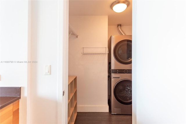 clothes washing area with stacked washing maching and dryer and dark hardwood / wood-style flooring