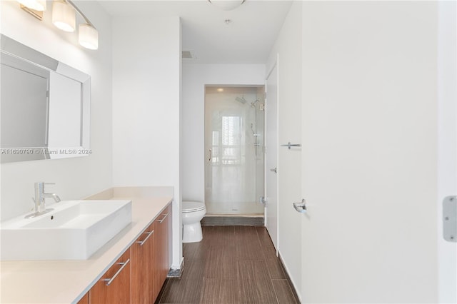 bathroom with toilet, vanity, and a shower with shower door