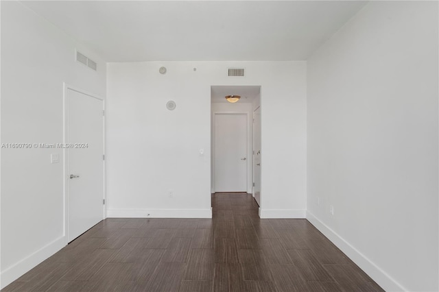 unfurnished room with dark hardwood / wood-style flooring