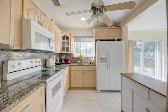 kitchen featuring light brown cabinets, white appliances, light stone counters, and tasteful backsplash