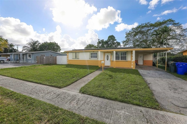 ranch-style house featuring a carport and a front lawn