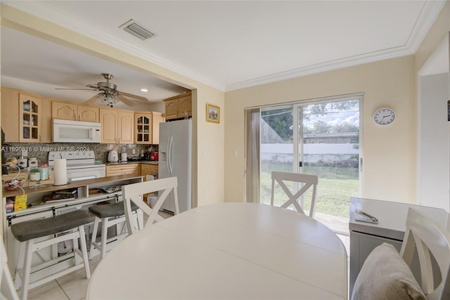 dining area with ceiling fan, crown molding, and light tile patterned floors