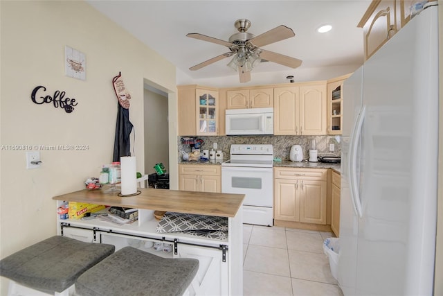 kitchen with decorative backsplash, kitchen peninsula, white appliances, and light tile patterned floors