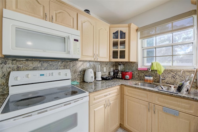 kitchen featuring sink, tasteful backsplash, light brown cabinets, white appliances, and dark stone countertops