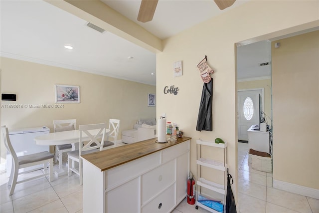 kitchen featuring light tile patterned flooring, ceiling fan, white cabinetry, and crown molding