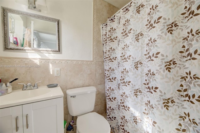 bathroom featuring curtained shower, vanity, toilet, and tile walls