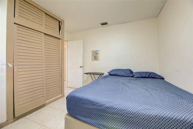 bedroom with a closet and light tile patterned floors