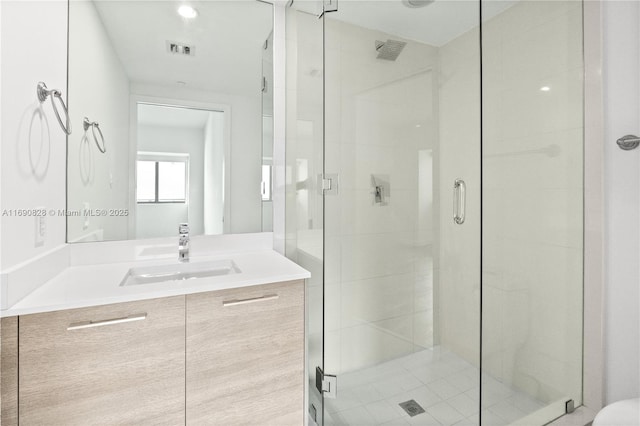 full bathroom featuring a shower stall, vanity, and visible vents