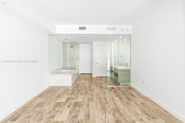 unfurnished room with baseboards, wood finished floors, and visible vents