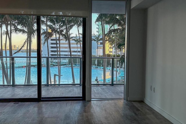 entryway with baseboards, wood finished floors, and a water view