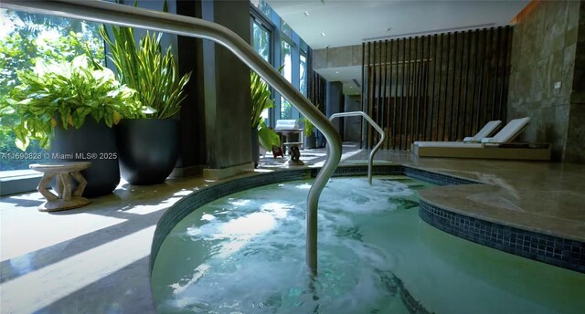 view of pool with an indoor hot tub