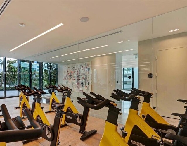 exercise room with expansive windows and wood finished floors