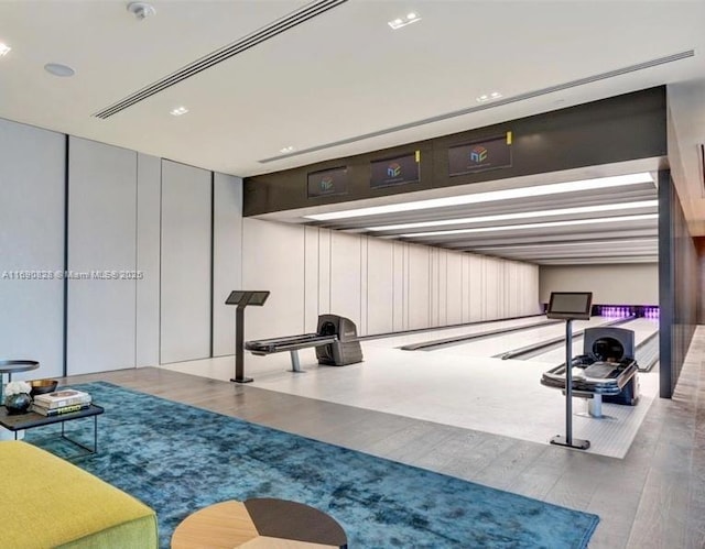 exercise room with a bowling alley and wood finished floors