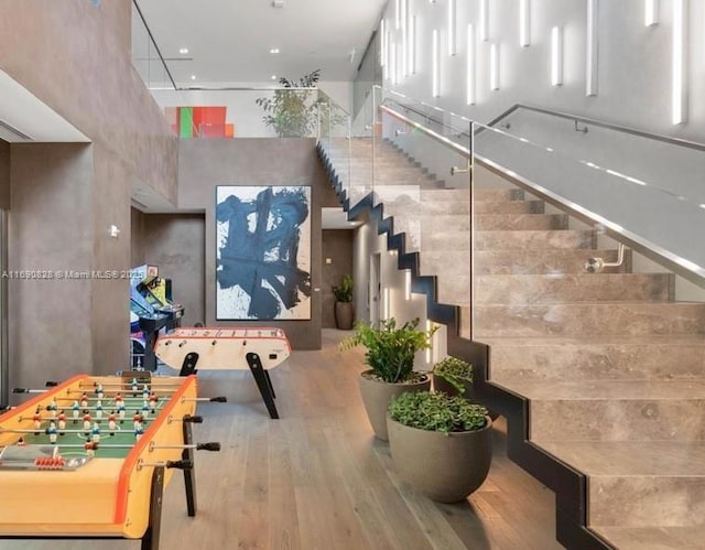 interior space featuring a towering ceiling and wood finished floors