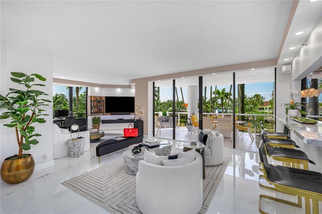 tiled living room featuring floor to ceiling windows and a textured ceiling