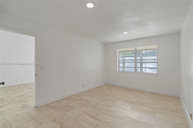 spare room with a textured ceiling