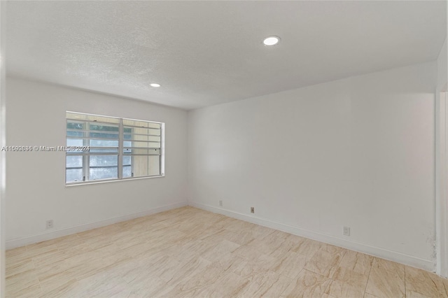 spare room with a textured ceiling