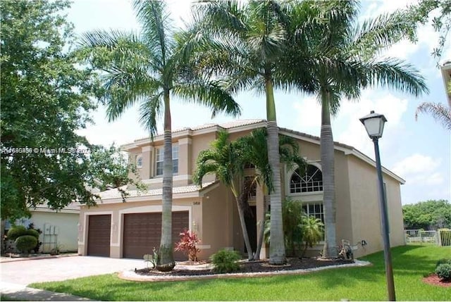 mediterranean / spanish house with a front yard and a garage