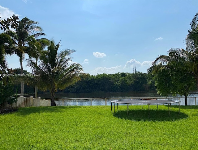 view of yard with a water view and a trampoline