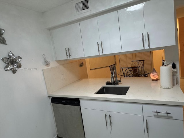 kitchen featuring white cabinets, stainless steel dishwasher, and sink