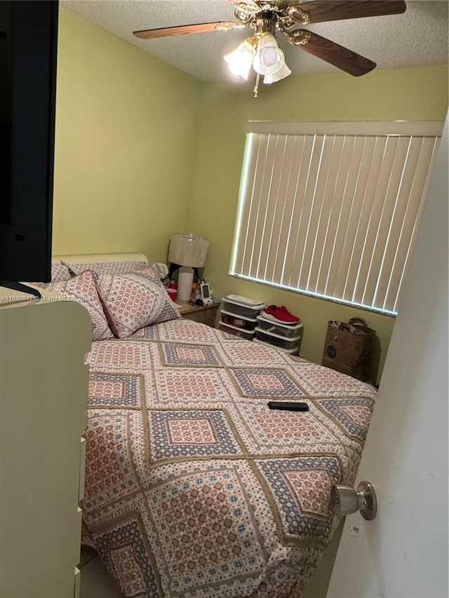 bedroom with ceiling fan and a textured ceiling