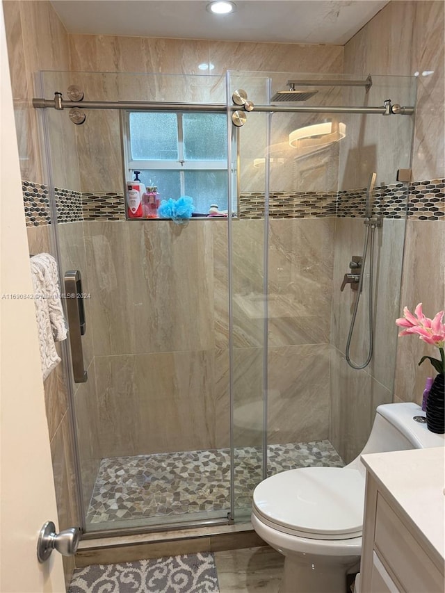 bathroom featuring walk in shower, vanity, and toilet