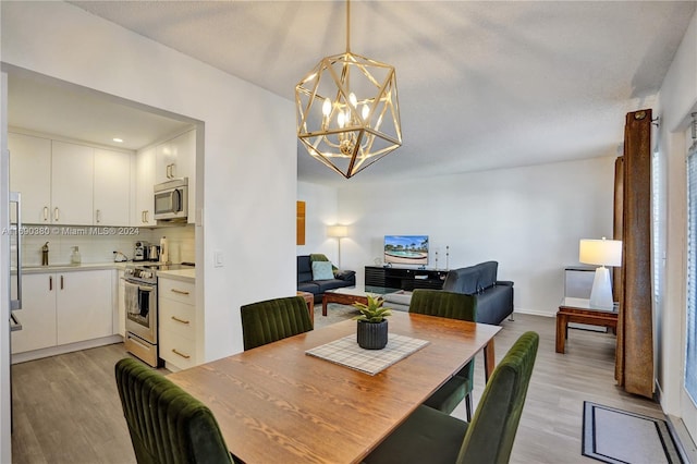 dining space featuring light hardwood / wood-style floors and a chandelier