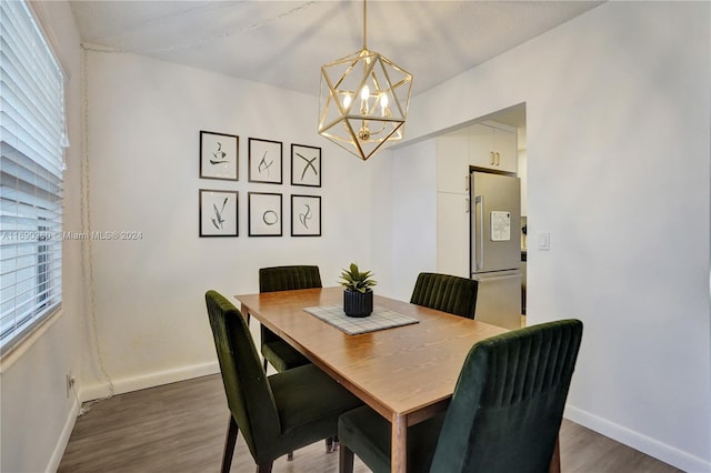 dining area with dark hardwood / wood-style flooring and a chandelier