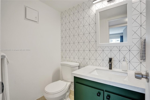 bathroom featuring tile walls, vanity, and toilet