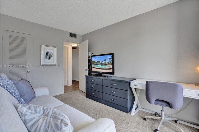 home office with a textured ceiling and light colored carpet