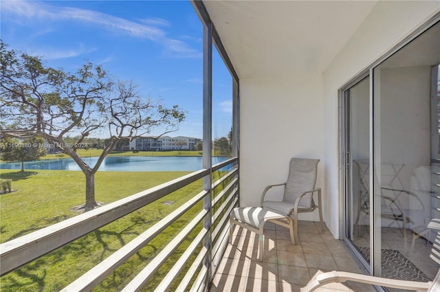 sunroom featuring a water view