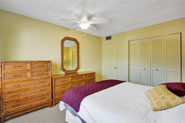 carpeted bedroom featuring a closet, a textured ceiling, and ceiling fan