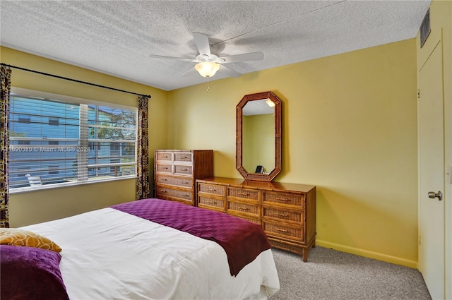 bedroom featuring a textured ceiling, light colored carpet, and ceiling fan