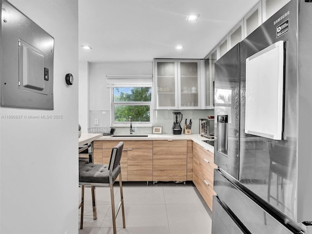 kitchen with fridge with ice dispenser, sink, and light tile patterned floors