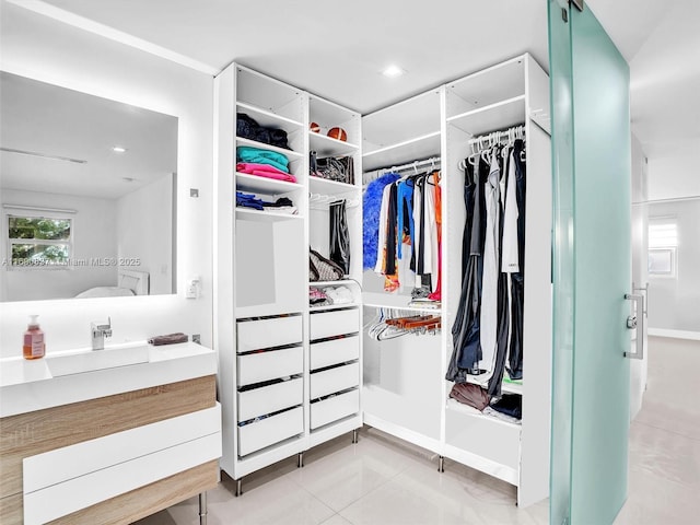 walk in closet featuring sink and light tile patterned floors