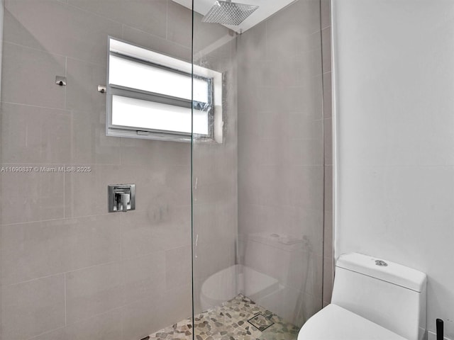 bathroom with toilet and tiled shower