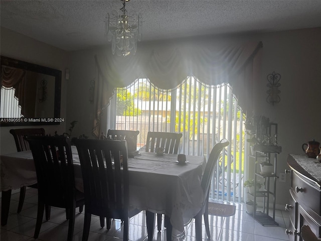 dining area with a textured ceiling, a notable chandelier, and light tile patterned floors