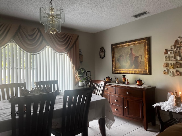 tiled dining area featuring a textured ceiling and a notable chandelier