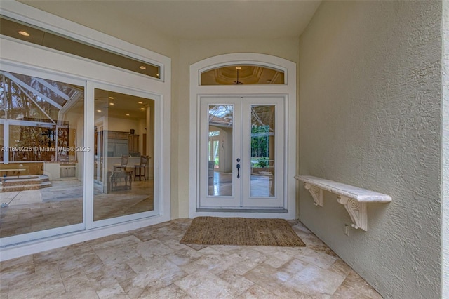 view of exterior entry with a patio area and french doors