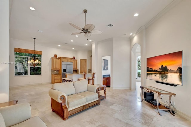 living room featuring ceiling fan and crown molding