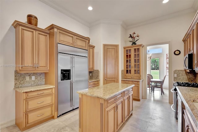 kitchen with appliances with stainless steel finishes, decorative backsplash, ornamental molding, and a kitchen island