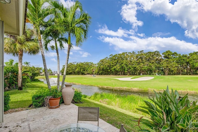 surrounding community with a water view and a lawn