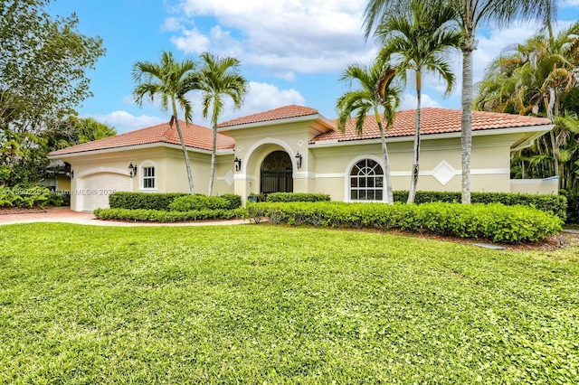 mediterranean / spanish house with a front lawn and a garage