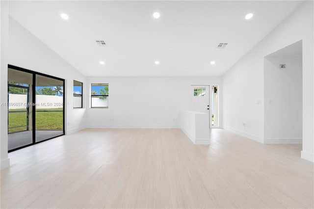 unfurnished room featuring light wood-type flooring and lofted ceiling